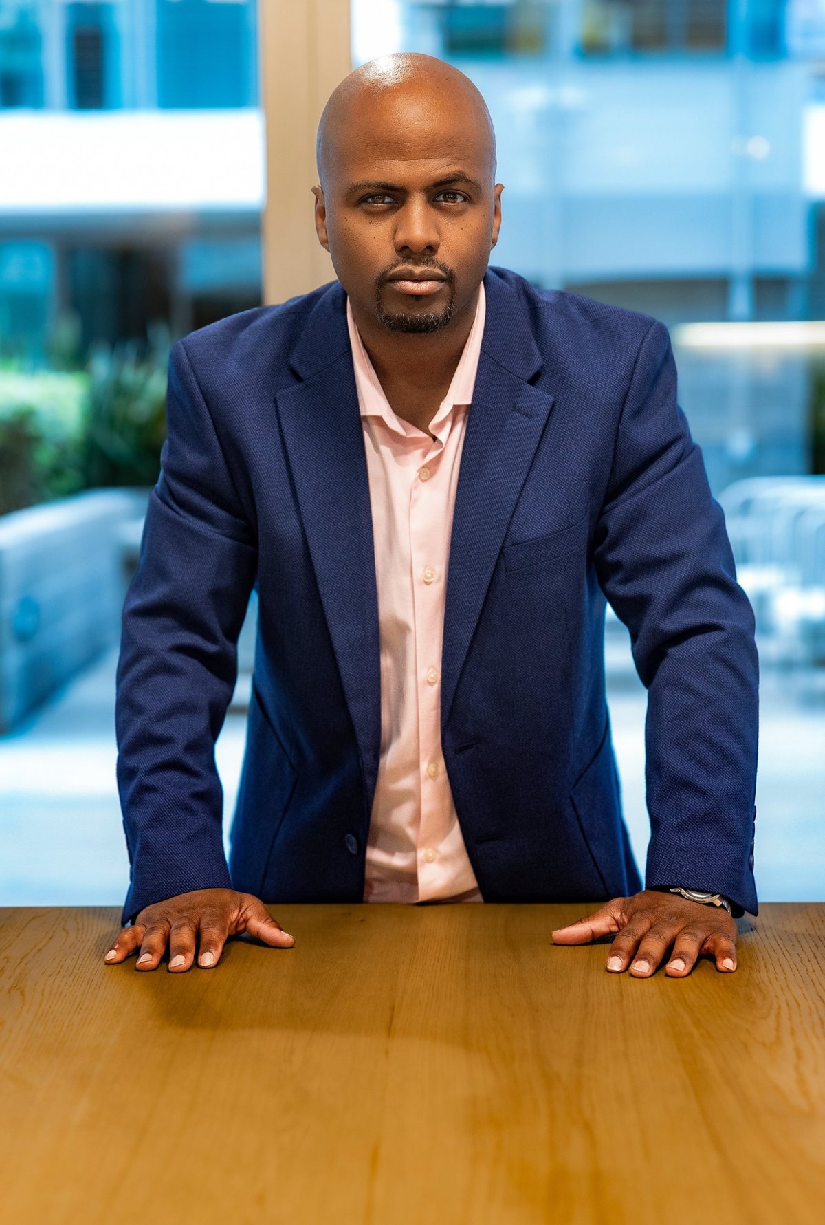 Lawrence R. Mike leaning forward with both hands on a conference table