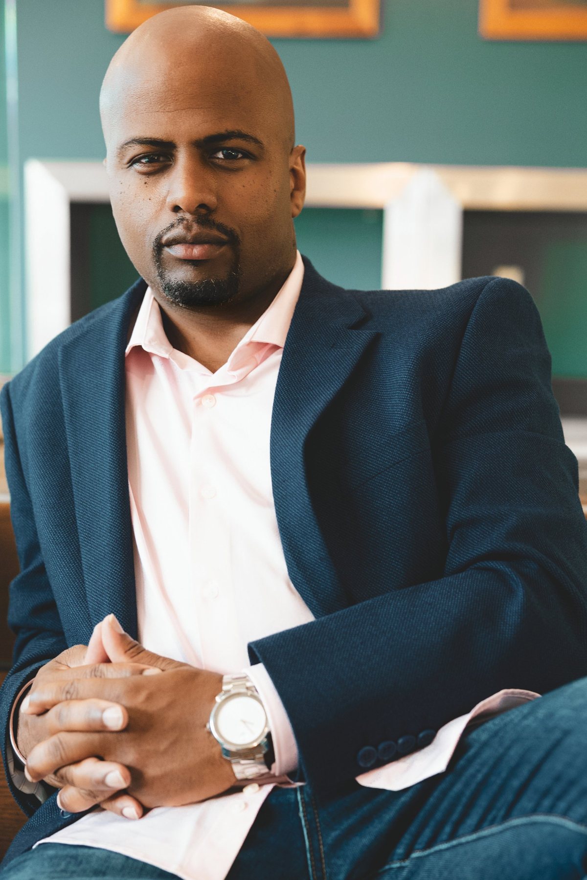 Lawrence R. Mike seated with hands clasped, in conversation